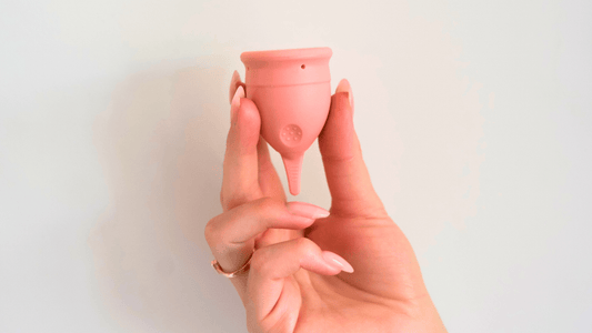 POM Finger Grip period cup in pink being held in fingers 