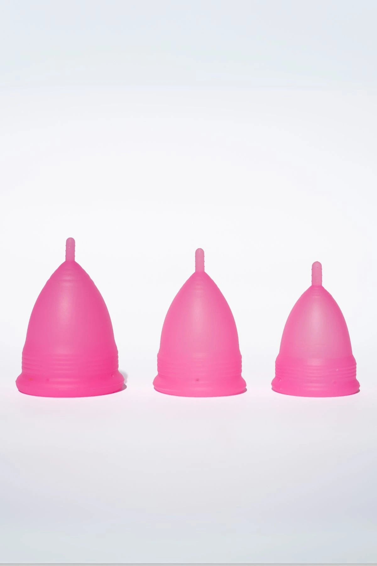 POM Super Soft Menstrual Cups in hot pink, shown in three sizes: large, small, and teen, made from 100% medical-grade silicone.